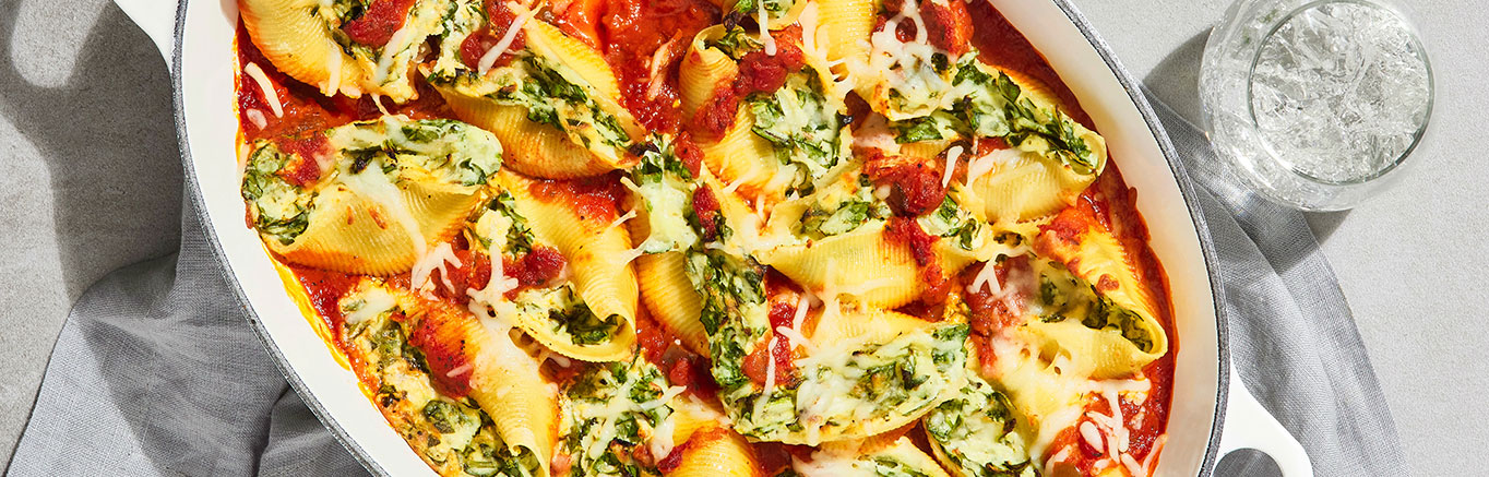 An image of prepared Spinach & Cheese Stuffed Shells made with pasta shells, baby spinach, ricotta cheese, mozzarella cheese, Parmesan cheese and Prego® Italian Sauce.