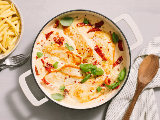 An image of prepared Marry Me Chicken Alfredo made with Prego® Homestyle Alfredo Sauce, chicken, sun-dried tomatoes, onion, Parmesan and basil.