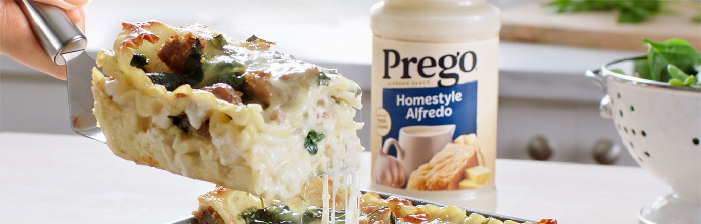 An image of prepared White Lasagna made with Prego® Homestyle Alfredo Sauce, lasagna noodles, sausage, baby spinach, ricotta, Parmesan and mozzarella.