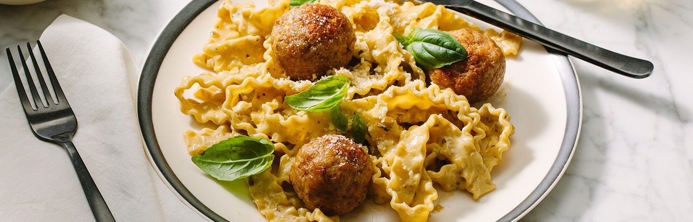 An image of prepared Creamy Pesto Turkey Meatballs made with with Prego® Creamy Roasted Garlic Pesto Sauce, ground turkey and Parmesan cheese.