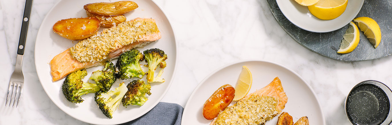 An image of prepared Parmesan-Crusted Pesto Salmon made with Yukon Gold potatoes, broccoli, salmon and Prego® Creamy Roasted Garlic Pesto Sauce.