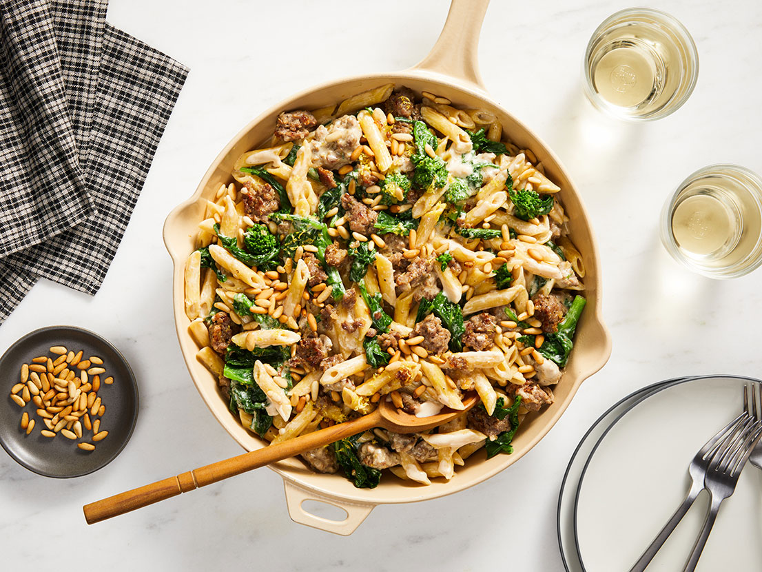 An image of prepared One Pot Sausage & Broccoli Rabe Pasta made with pork sausage, broccoli rabe, Prego® Garlic & Caramelized Onion Alfredo Sauce, Swanson® Natural Goodness® Chicken Broth and penne pasta.